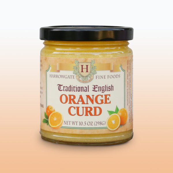 A glass jar with a black cap filled with Orange Curd. The label states it is made by Harrowgate Fine Foods, and is Traditional English Orange curd.