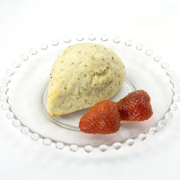 Indian Chai Scone made with Indian Chai Scone Mix; the scone is sitting on a clear glass plate, and the plate is garnished with fresh strawberries.