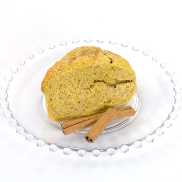 Pumpkin scone made with pumpkin spice Scone mix. Sitting on glass plate, with two cinnamon sticks garnishing the plate.